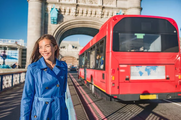 Mulher de Londres a pé viajar na rua Tower Bridge City usando ônibus de transporte público pendulares pela manhã. feliz jovem asiático britânico empresário vai para o trabalho ou turista cidade viagens — Fotografia de Stock