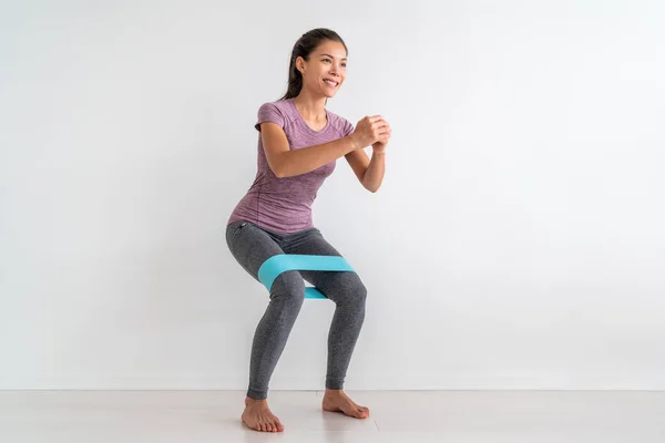 Weerstandsband oefeningen met stof elastische apparatuur. Krab lopen squat oefening fit aziatische fitness vrouw training thuis — Stockfoto