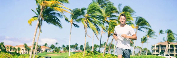 Runner running man joggen in tropische zomer buiten gelukkig leven een gezonde en actieve levensstijl. Panoramische achtergrond met palmbomen, Joggertraining buiten — Stockfoto