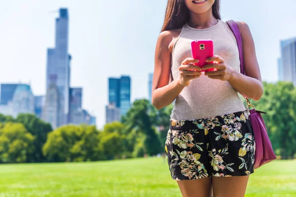 Urbano moderno NYC cidade estilo de vida mulher smartphone. Pessoa SMS sms no telefone celular em Central Park Meadow, Nova York. Viagem de férias de verão — Fotografia de Stock