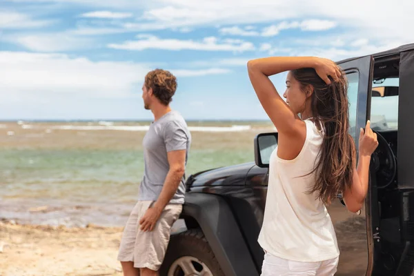 Pareja en un viaje por carretera vacaciones en Hawai coche de conducción en la playa. Jóvenes turistas disfrutando de vacaciones —  Fotos de Stock