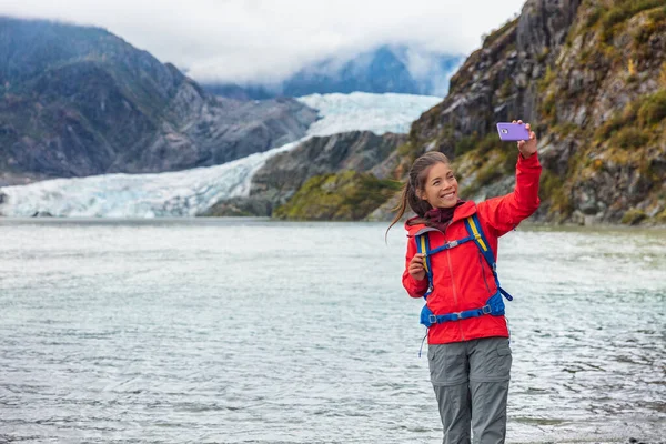 Tourist woman taking selfie photo at Mendenhall glacier in Juneau, Alaska. Famous tourism destination on Alaska cruise, USA travel — Stock Photo, Image