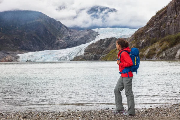 Vandrare turist promenader på spår av Mendenhall glaciär, Alaska vandring destination resa semester. Asiatisk kvinna vandring av isvatten med is bakgrund — Stockfoto