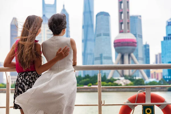 Duas mulheres pegando o ferry na cidade de Xangai, China, cruzando o rio Bund olhando para a vista da famosa torre de TV pérola, marco. Viagens pessoas estilo de vida. — Fotografia de Stock