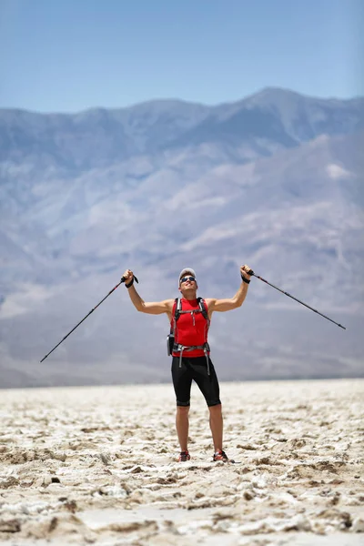 Caminante sosteniendo postes contra montaña — Foto de Stock