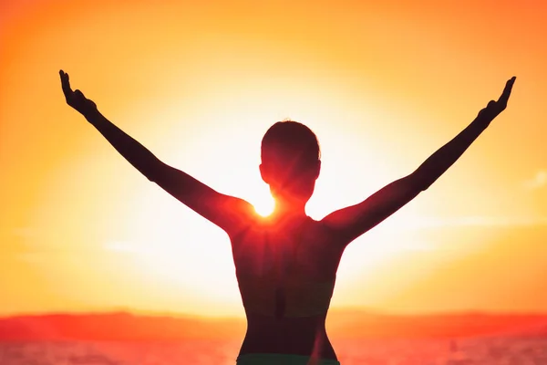 Mujer feliz despreocupada con silueta de brazos abiertos al atardecer. Libertad de éxito concepto de vida feliz en la salida del sol. Chica de yoga de la mañana practicando el saludo al sol al aire libre. Persona despreocupada que vive una vida libre —  Fotos de Stock