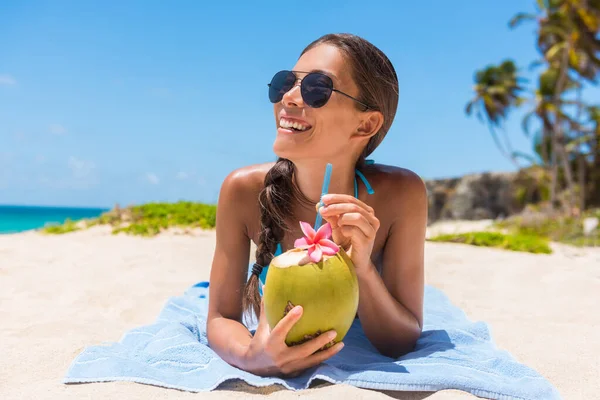 Güneş gözlüklü plaj kadını Hindistan cevizi suyu içiyor yaz tatilinde eğleniyor. Tropik seyahat tatili. Bikinili sıradan bir kız, doğal sağlıklı içeceklerle dinleniyor. — Stok fotoğraf
