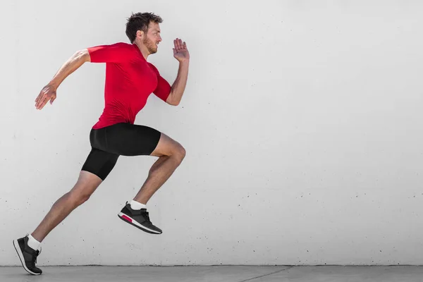 Běžící man runner trénink dělat venkovní město běh sprintovat podél zdi pozadí. Městský zdravý aktivní životní styl. Muž atlet dělá sprint hiit vysoký interval intenzity trénink. — Stock fotografie