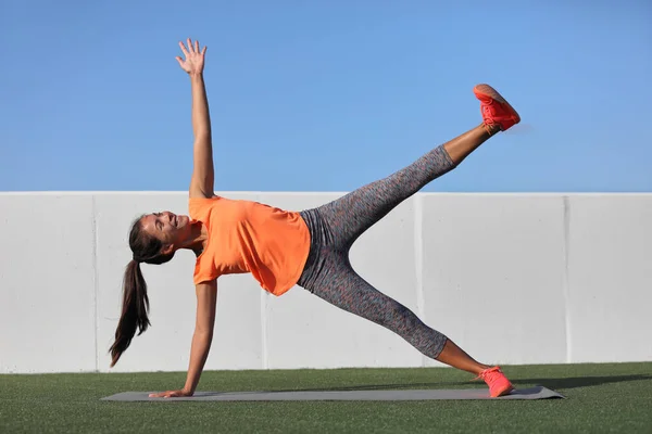Star Side Plank. Yoga vrouw planking doen been lift core oefening in fitness gym klasse. Aziatisch meisje training side plank been verhogen lichaam kern in yoga studio op thuis outdoor gras. Fitness sportschool levensstijl. — Stockfoto