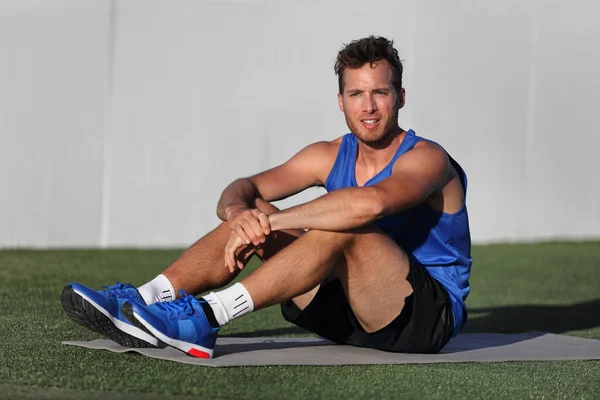 Gym fitness man porträtt avkopplande på träningsmatta på utomhus park. Happy fit manlig idrottsman hälsosam aktiv livsstil redo för morgon yoga praxis hemma på gräs. — Stockfoto