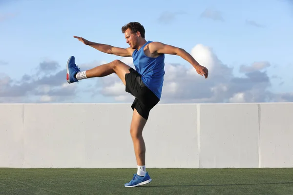 Runner Man preparándose para correr haciendo ejercicios de estiramiento dinámico de piernas de calentamiento rutina, atleta masculino estirando los músculos isquiotibiales del cuerpo inferior antes de salir a correr al aire libre en verano. — Foto de Stock