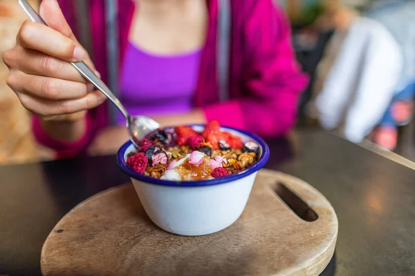 Mujer del cuenco Acai desayunando por la mañana en el café. Primer plano de la dieta saludable batido de frutas para la pérdida de peso con bayas y avena. Comida orgánica vegana cruda saludable. —  Fotos de Stock