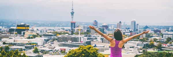 Blick auf die Skyline von Auckland vom Mount Eden Banner. Sky Tower, Neuseeland. Glückliche Frau mit erhobenen Armen in Freiheit und Glück auf der Spitze des Mt Eden Stadtparks berühmte Touristenattraktion. — Stockfoto