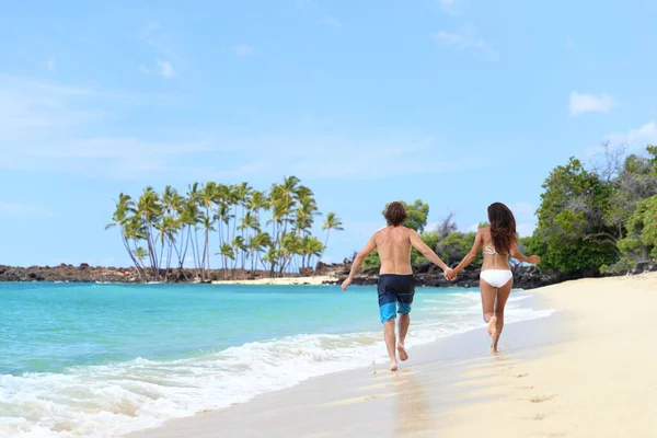 Glückliches Paar hält Händchen am lustigen Urlaubsstrand — Stockfoto