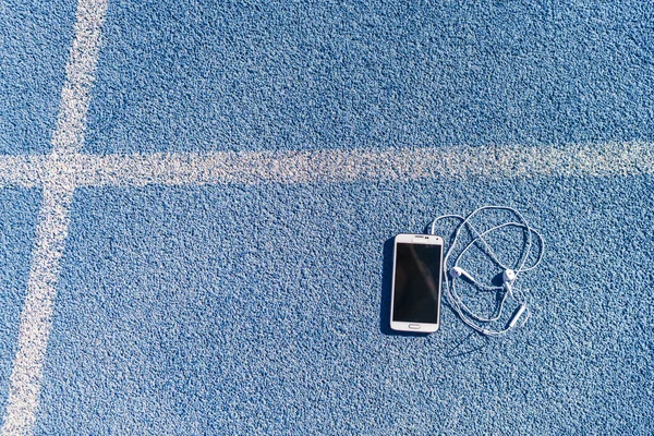 Trilha de corrida e pista de campo música do telefone móvel — Fotografia de Stock