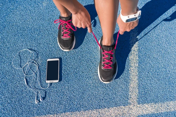 Бігун зав'язує бігові шнурки на біговій доріжці — стокове фото