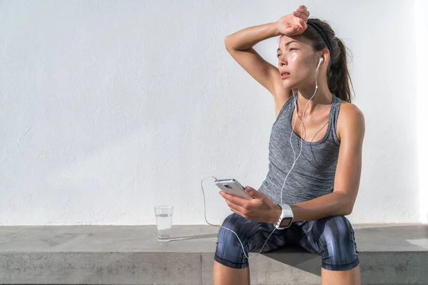 Müde Fitness-Frau schwitzt beim Musikhören — Stockfoto