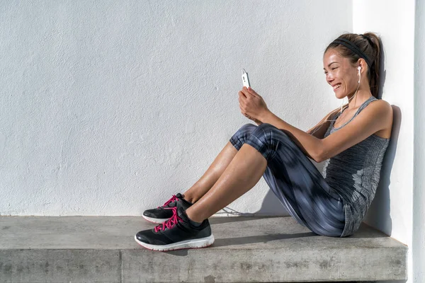 Mujer fitness escuchando música de teléfono con motivo —  Fotos de Stock