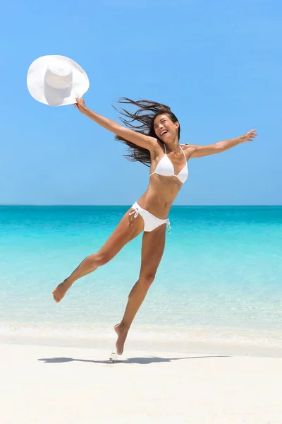 Glad bekymmerslös flicka hoppar på kul strand semester — Stockfoto