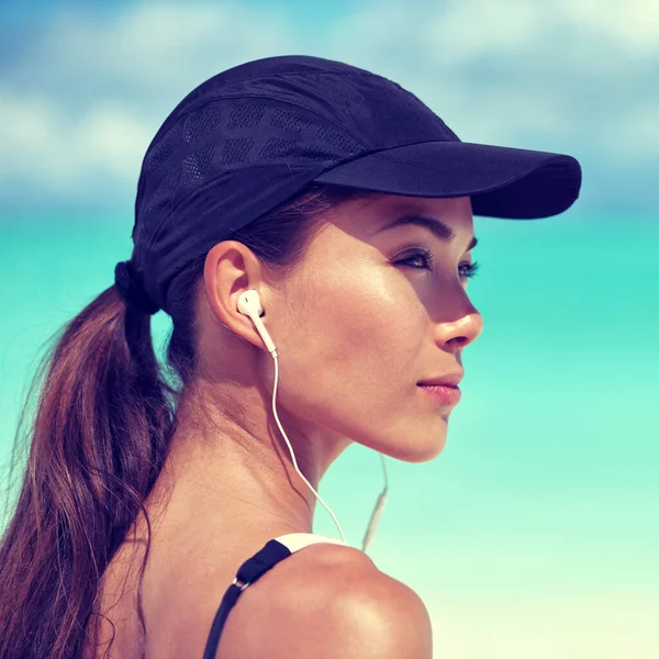 Fitness runner woman listening to music on beach — Stock Photo, Image