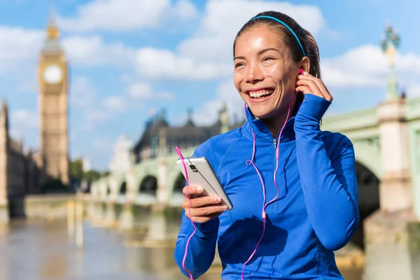 Chica corriendo de Londres escuchando música de teléfonos inteligentes —  Fotos de Stock