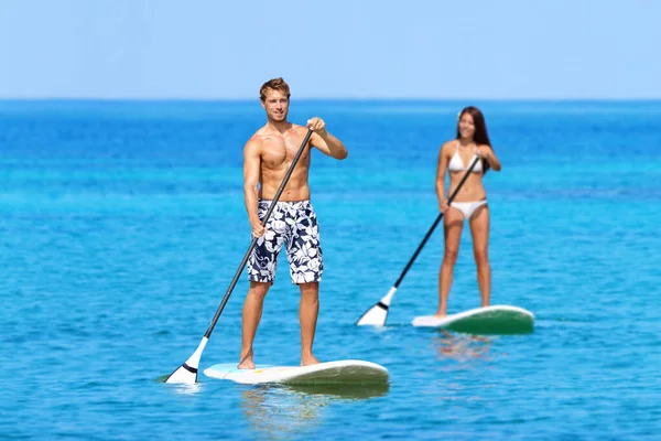 Par som reser sig upp Paddleboarding On Ocean — Stockfoto