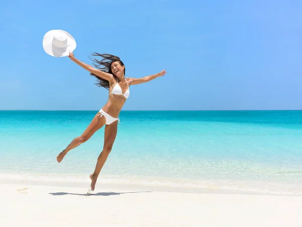 Obekymrad kvinna hoppar på stranden under sommaren — Stockfoto