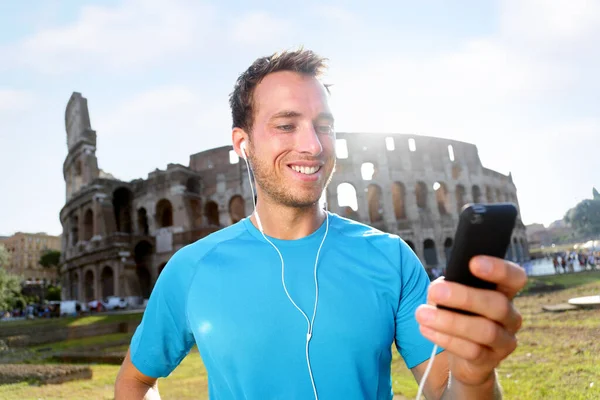 Glückliche Joggerin hört Musik gegen Kolosseum — Stockfoto