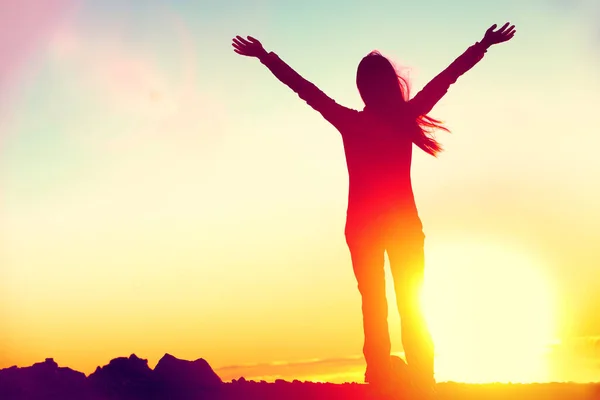 Felice di celebrare la donna vincente successo al tramonto o l'alba in piedi euforico con le braccia alzate sopra la testa in celebrazione di aver raggiunto l'obiettivo cima della montagna durante trekking viaggio. — Foto Stock