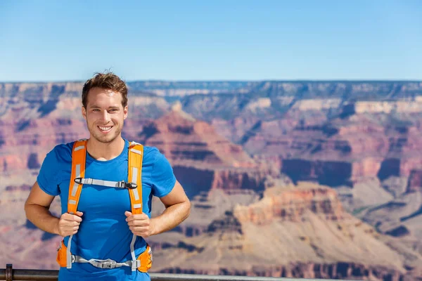 Grand Canyon hiker man portrait with backpack bag. Hiking male tourist on Grand Canyon, Arizona, USA. Hiking athlete enjoying view of nature landscape wearing backpack. Young man relaxing after hike. — Stock Photo, Image