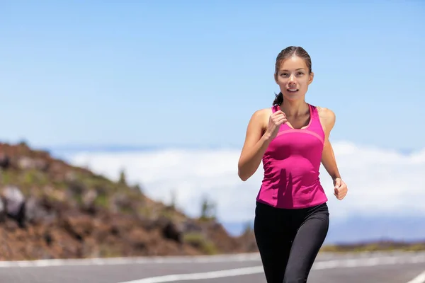 マラソンレースランのための道路のトレーニングで女性ランナージョギング屋外を実行しているスポーツ選手に適合します。屋外で働くアジアの若い女性心臓を実行しています。美しいフィットフィットネスモデルで彼女の20代. — ストック写真