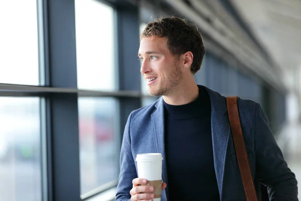 Šťastný podnikatel jde do práce pití kávy - cestovní životní styl nebo dojíždění městského života. Mladý profesionální muž v blízkosti okna v kanceláři budovy nebo na letišti terminálu business class letu. — Stock fotografie