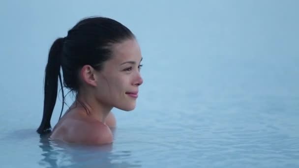 Islândia geotérmica spa. Mulher relaxante na piscina termal na Islândia. Menina que gosta de tomar banho em uma lagoa de água azul tradicional atração turística islandesa — Vídeo de Stock