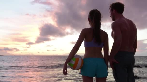 Friends talking after beach volleyball active fun living sporty active lifestyle. Portrait of people with volley ball after game in summer. Woman and man fitness model enjoying sunset — Stock Video