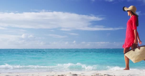 Turista de ropa de playa con sombrero de sol de paja y bolso de playa caminando en vacaciones tropicales de verano, usando sombrero de sol y vestido de túnica roja encubrimiento relajante en vacaciones de viaje. VIDEO DE MOCIÓN LENTA — Vídeo de stock