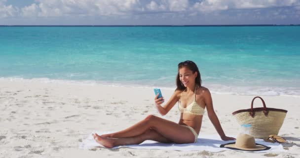 Summer beach vacation girl taking mobile phone selfie photo with. Cute Asian woman wearing posing for phone self-portrait photo enjoying suntan on tropical travel holidays — Stock Video