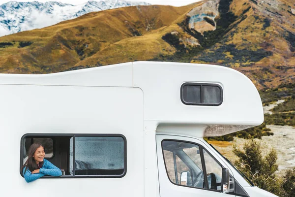 Viaje por carretera RV turista mujer mirando por la ventana de su autocaravana en los viajes de Nueva Zelanda. Feliz chica asiática joven que viaja al aire libre en vacaciones de aventura conduciendo una caravana. Hogar lejos de casa —  Fotos de Stock