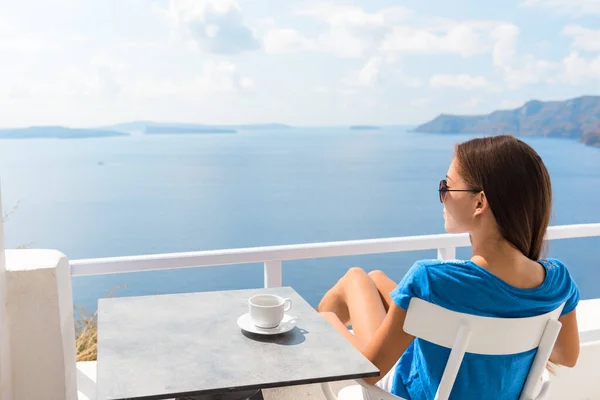 Otel balkonunda dinlenen bir kadın sabah kahvaltısında deniz manzarası seyrediyor kahve fincanı içiyor. Lüks tatil beldesi tatil hayatı kızı masada oturuyor. — Stok fotoğraf