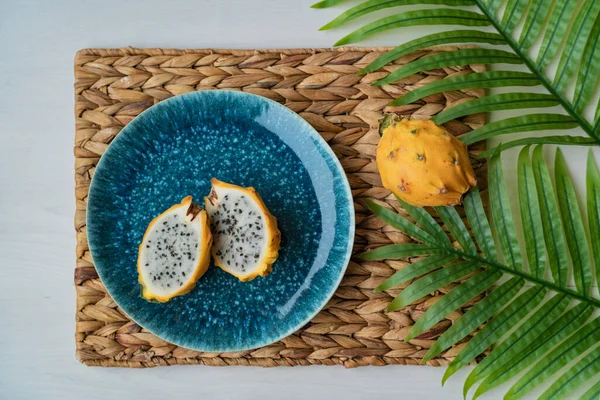 Masadaki mavi tabakta servis edilen sarı pitaya ejder meyvesi. Organik ejderha meyvesi taze ve sağlıklı. Hylocereus megalanthus — Stok fotoğraf