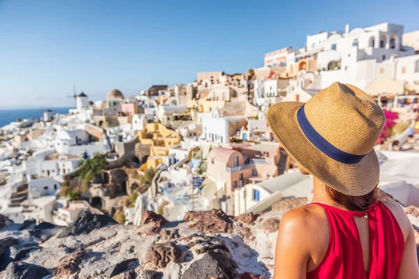 Podróże wakacje Greece Santorini kobieta turysta patrząc na Oia widok wsi, luksusowe wakacje Europa przeznaczenia. Wakacje letnie — Zdjęcie stockowe