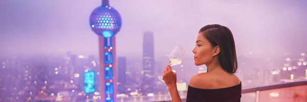 Luxo estilo de vida Xangai mulher asiática bebendo vinho branco na China Travel. Modelo elegante em vestido preto na vista terraço da cidade, vida high-end — Fotografia de Stock