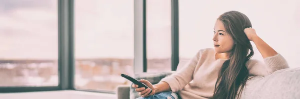 Casa feliz sala de estar Mujer asiática viendo televisión relajante en sofá en apartamento condominio pancarta encabezado panorámico — Foto de Stock