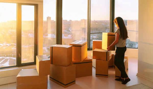 Mudándose a un nuevo servicio de recogida de mudanzas. Mujer lista para mudarse del apartamento con pertenencias empaquetadas en muchas cajas de cartón paquetes para enviar — Foto de Stock