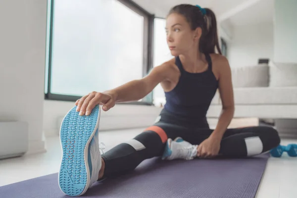 Fitness thuis Aziatische vrouw stretching beenspieren op trainingsmat voor trainingspilates of hiit workout. Sluiten van loopschoenen — Stockfoto