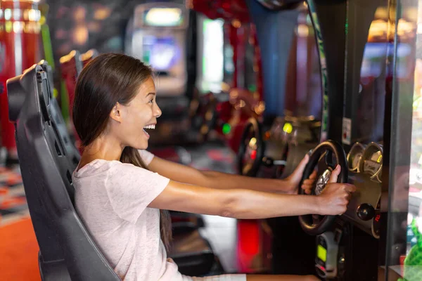 アーケードゲーム機大人の女性が仮想スポーツ車を運転レースカービデオゲームを楽しんでいる — ストック写真
