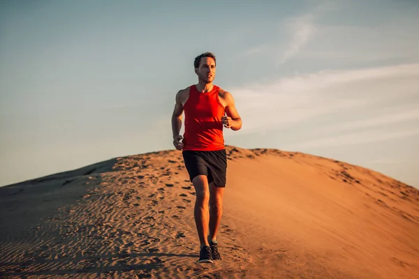 Trilha atleta corredor corredor homem no deserto areia dun no calor do verão pôr do sol dia — Fotografia de Stock