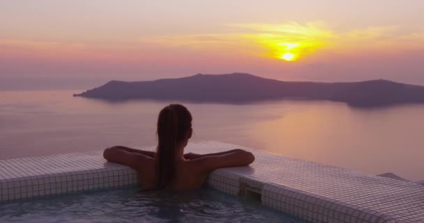 Женщина в бассейне Spa Наслаждаясь закатом над морем на Санторини, Греция, Европа — стоковое видео