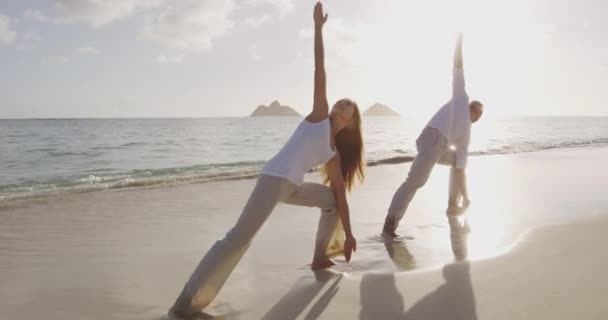 Clase de yoga - las personas que hacen yoga posan en la playa — Vídeo de stock