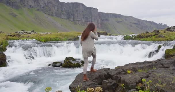 在冰岛瀑布边散步的快乐女人 — 图库视频影像