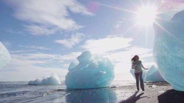 Islandia Jokulsarlon Iceberg playa - turista caminando por los icebergs en la playa de hielo — Vídeo de stock